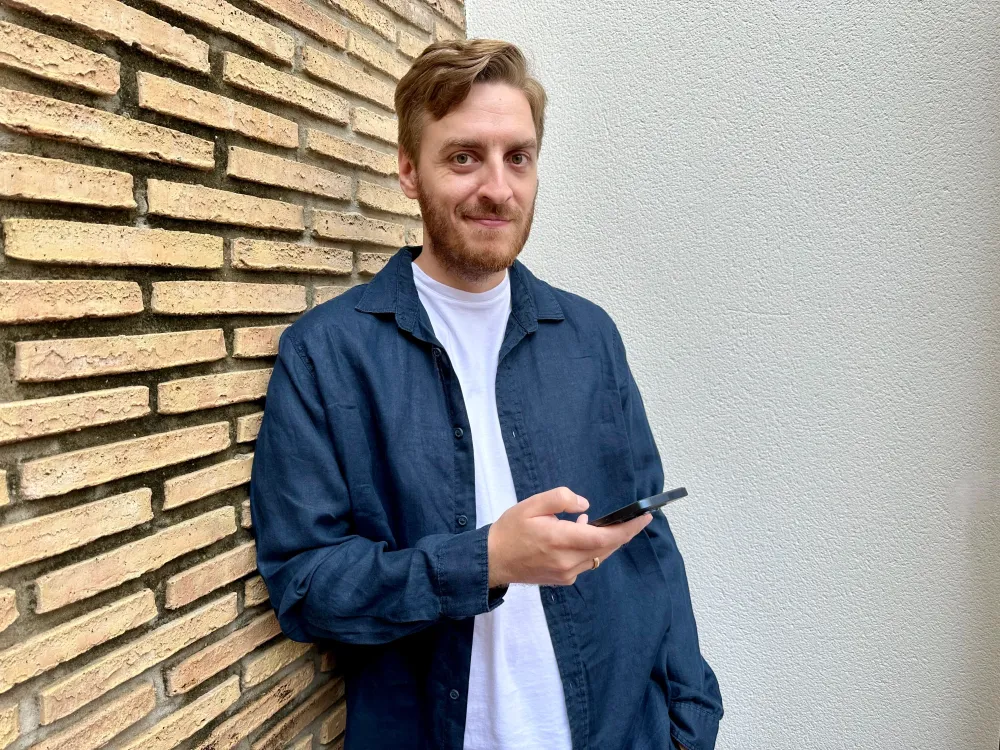 Benjamin Schneider mit Handy in der Hand